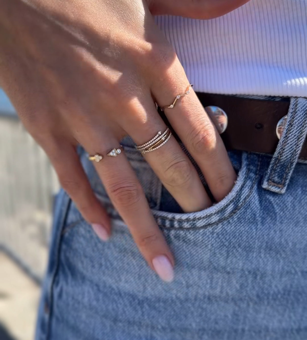 Hand wearing 14K gold and diamond stackable rings for everyday styling